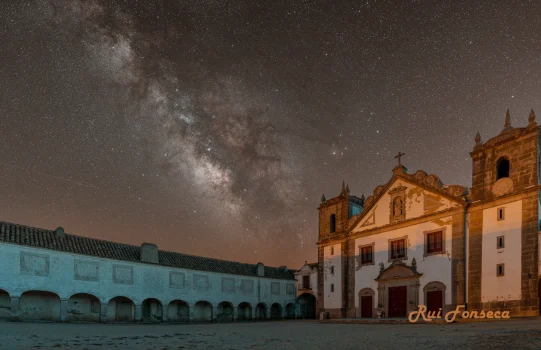 Night photography of a historic building with a starry sky backdrop.