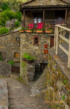 A picturesque view of a stone village nestled in a lush, green landscape, showcasing traditional architecture and a tranquil atmosphere.