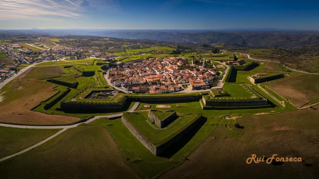 Aerial view of the star-shaped fortress of Castelo Rodrigo, Portugal, surrounded by agricultural fields and a small town.