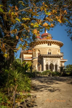 A view of the Quinta da Regaleira palace in Sintra, Portugal, framed by autumn foliage.