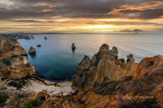 Panoramic view of the coastline with rock formations and a sunset.